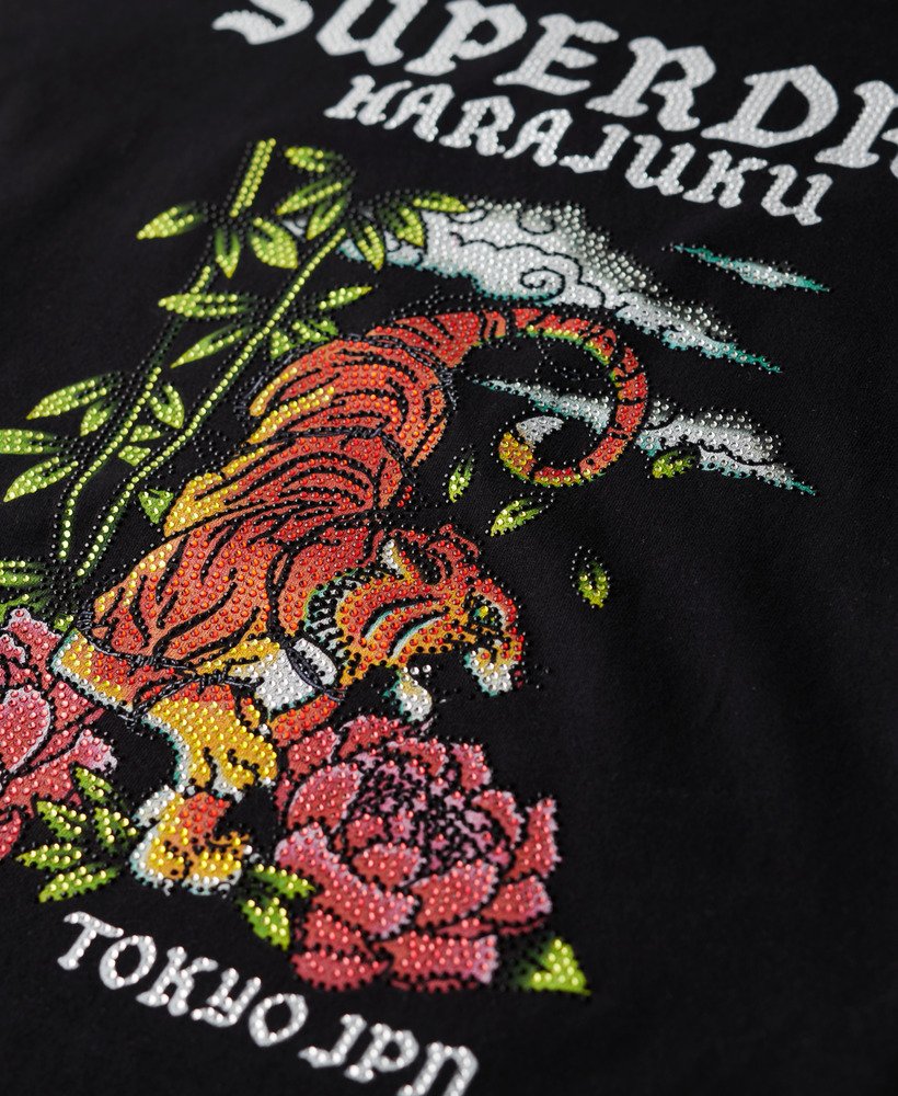 camiseta preta com estampa de tatuagem e strass.