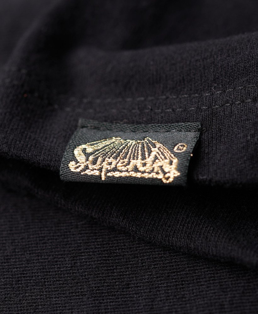 camiseta preta com estampa de tatuagem e strass.