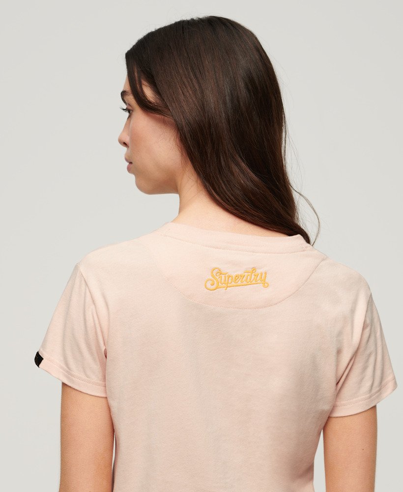 camiseta ajustada bordada com tatuagem na cor rosa pêssego.