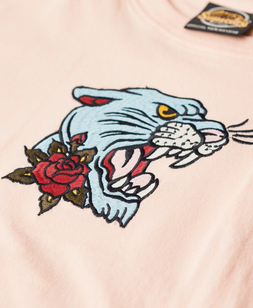 camiseta ajustada bordada com tatuagem na cor rosa pêssego.