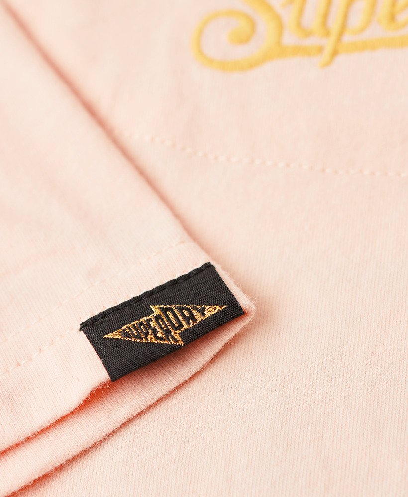 camiseta ajustada bordada com tatuagem na cor rosa pêssego.