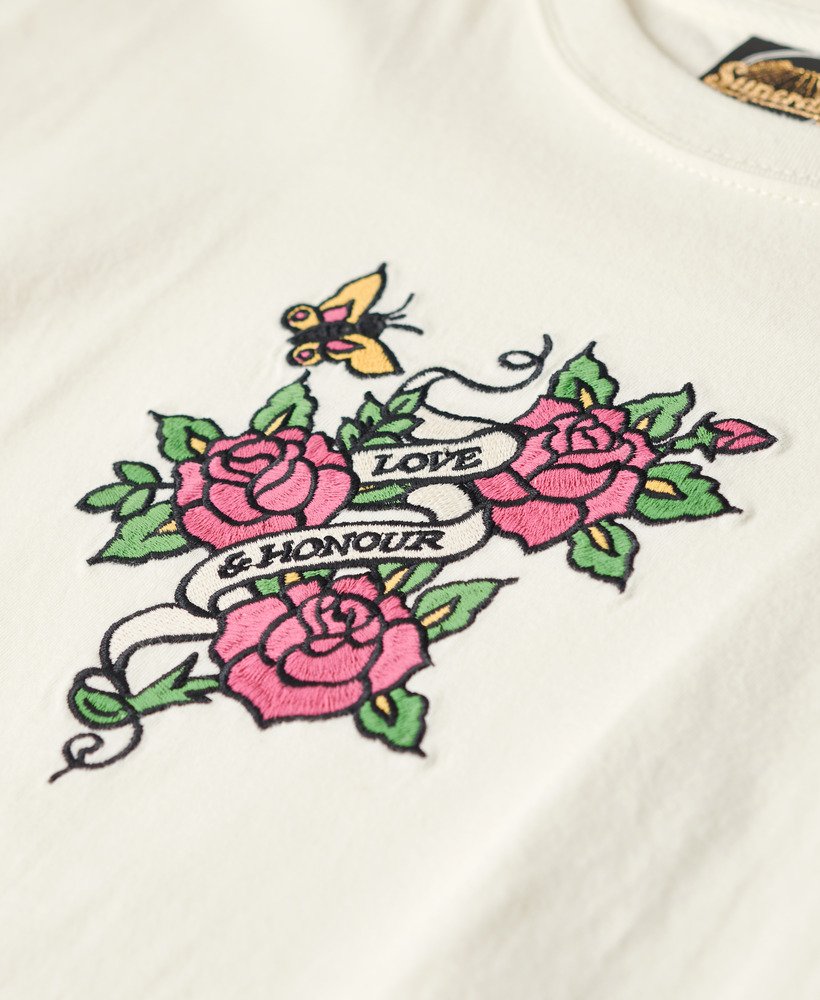 camiseta ajustada bordada com tatuagem na cor creme.