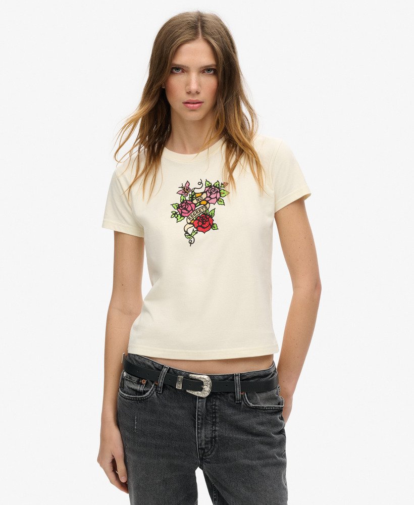 camiseta justa com estampa de tatuagem pequena e strass na cor branca arroz.
