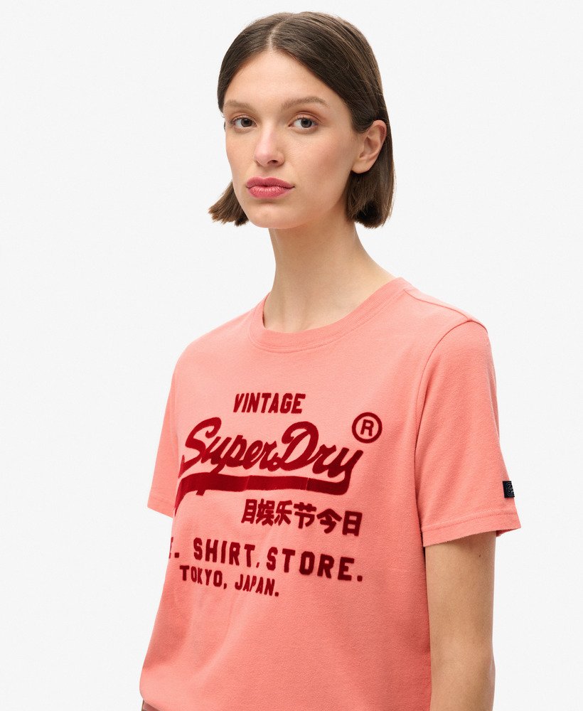 camiseta clássica vintage com estampa de logo e modelagem relaxada na cor coral queimado.