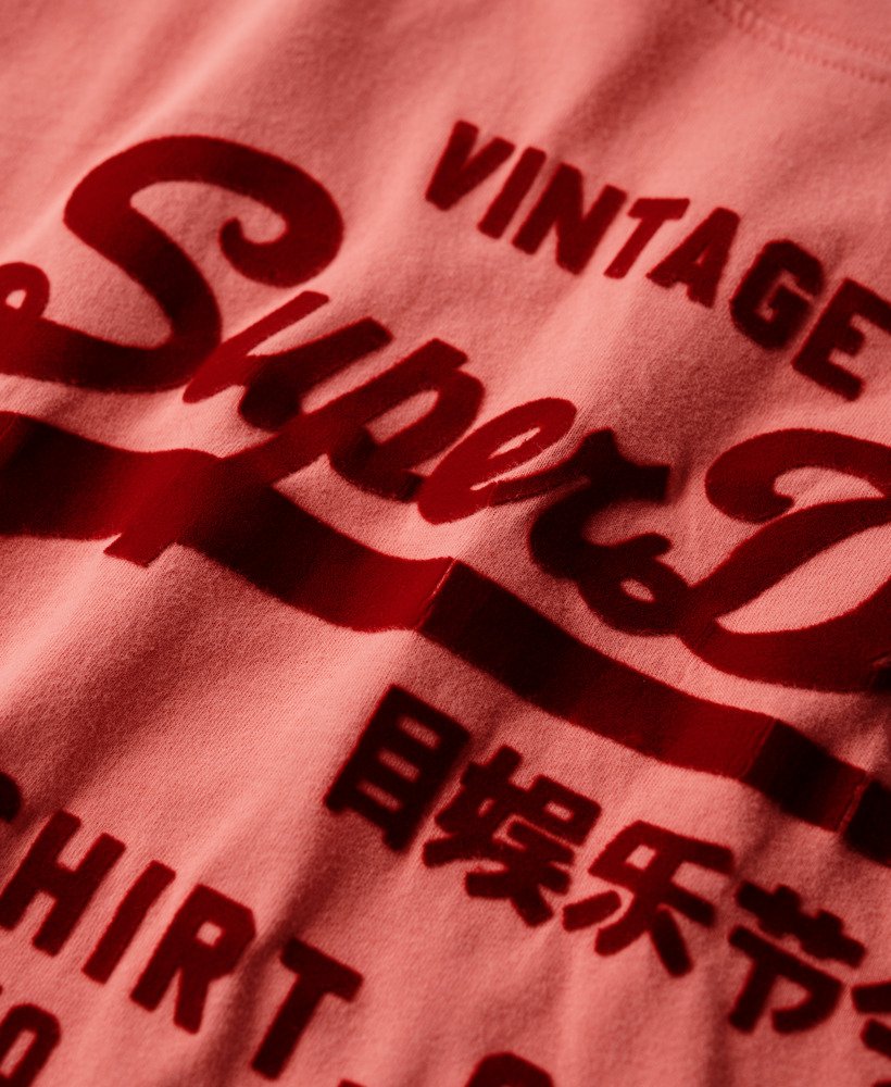 camiseta clássica vintage com estampa de logo e modelagem relaxada na cor coral queimado.