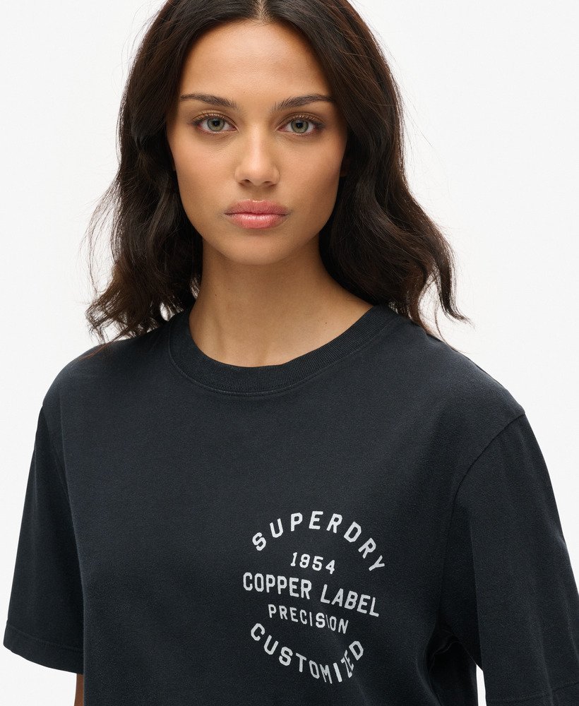 camiseta oversized com estampa da etiqueta de cobre no peito na cor preto jato.