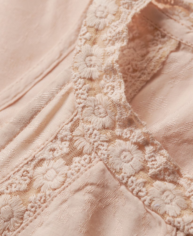 blusa de renda sem mangas com gola alta em tom rosa claro