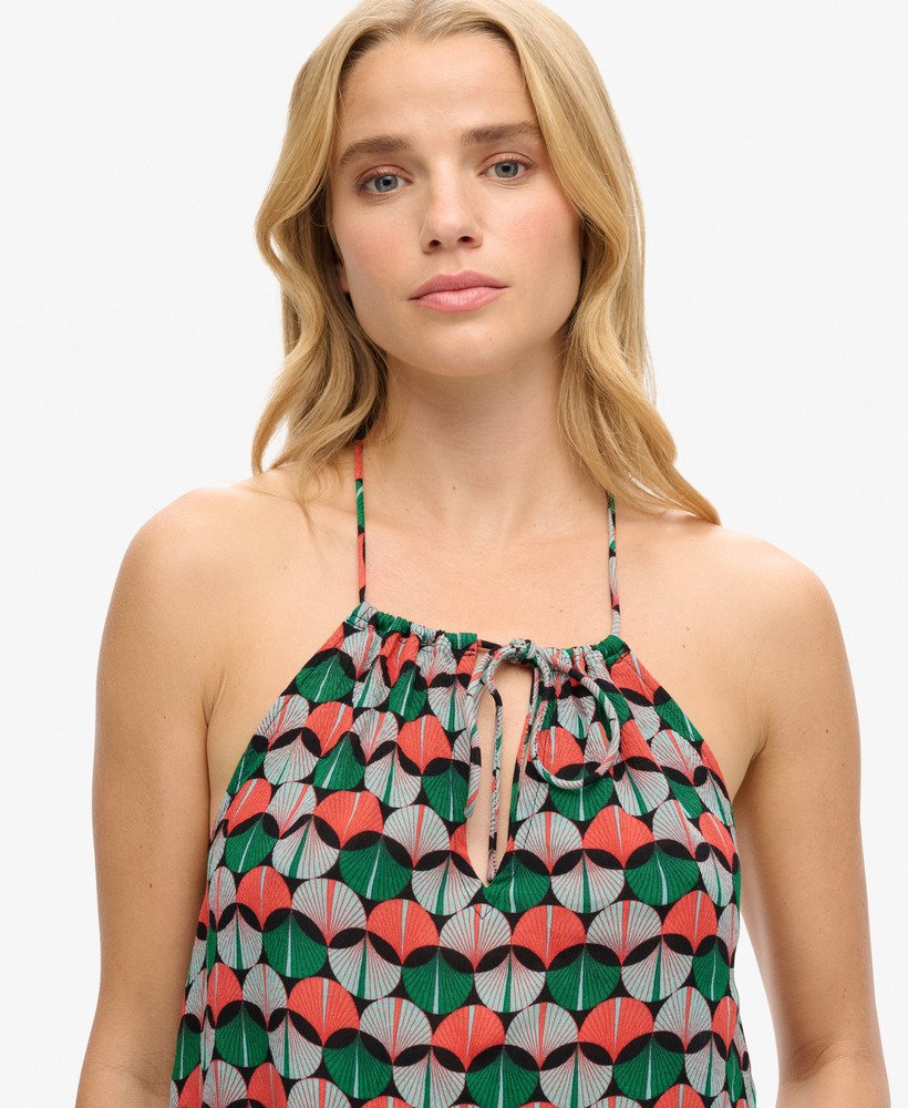 top de praia estampado com decote halter em padrão geométrico laranja.
