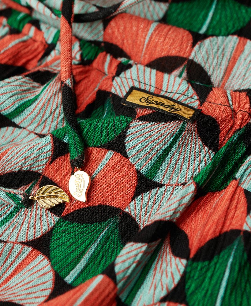 top de praia estampado com decote halter em padrão geométrico laranja.
