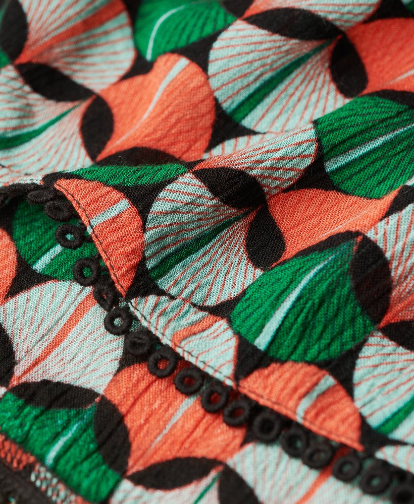 top de praia estampado com decote halter em padrão geométrico laranja.