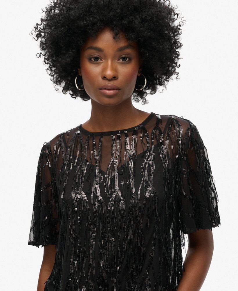 blusa transparente de manga curta com lantejoulas e franjas pretas.