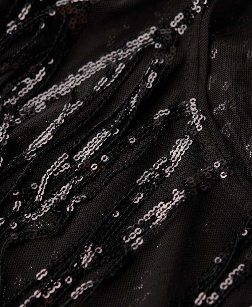 blusa transparente de manga curta com lantejoulas e franjas pretas.