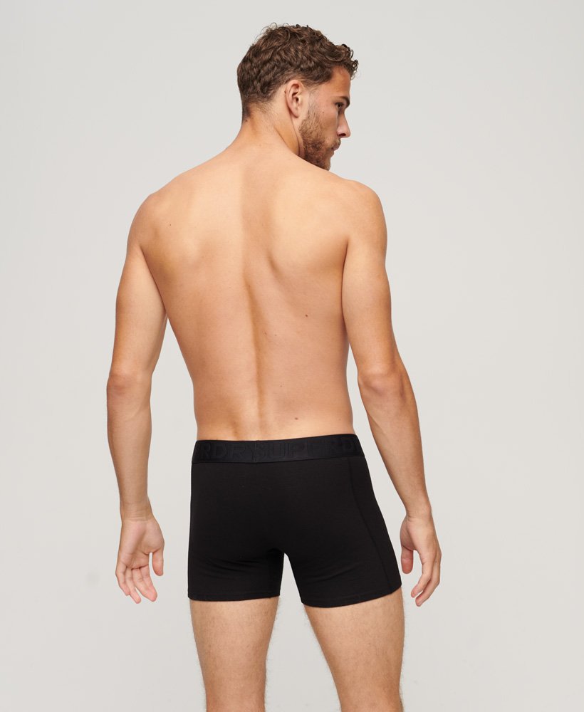 pacote com três cuecas boxer de algodão orgânico na cor preta.